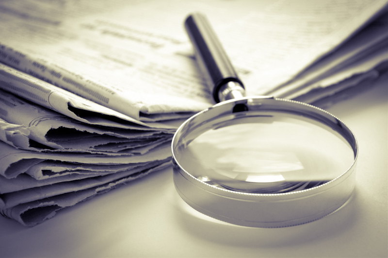 How to change your name in Nigeria and picture of a daily newspaper and a hand lens for checking to pick the cheapest newspaper to publish change of name in Nigeria